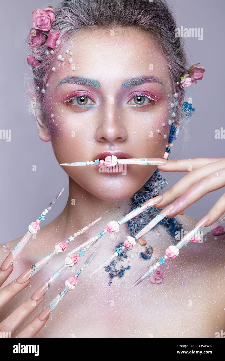 Belle fille à l'image d'une jolie fée avec un art de la taille et avec de longs ongles design. Manucure créative. Banque D'Images