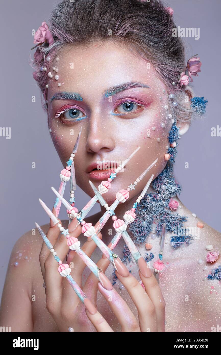 Belle fille à l'image d'une jolie fée avec un art de la taille et avec de longs ongles design. Manucure créative. Banque D'Images