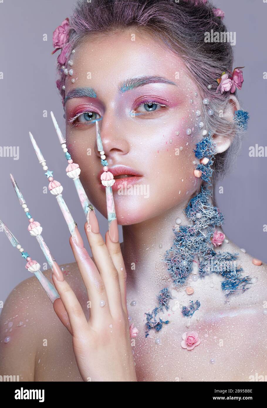 Belle fille à l'image d'une jolie fée avec un art de la taille et avec de longs ongles design. Manucure créative. Banque D'Images