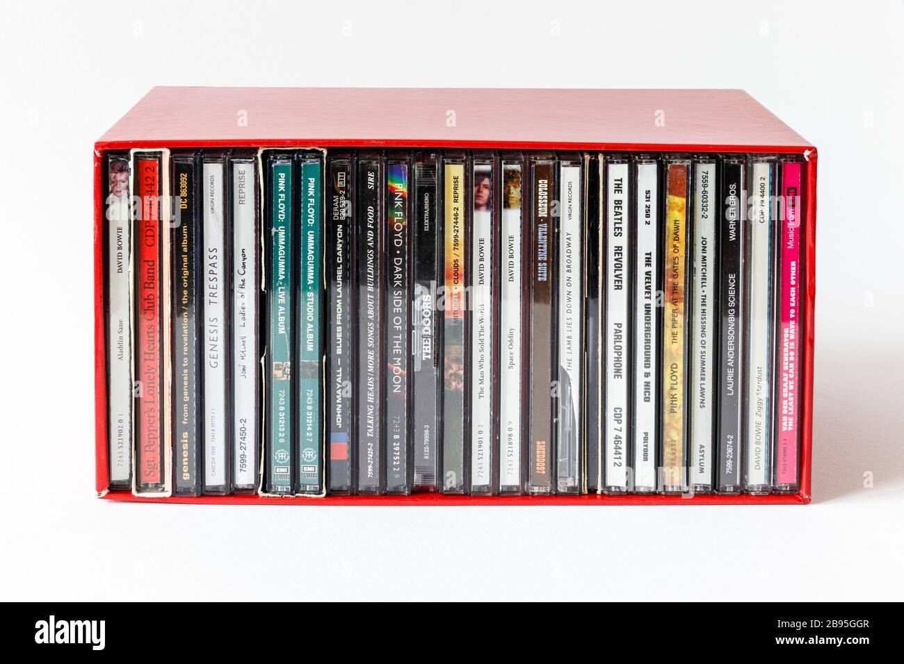 Une boîte rouge contenant des CD empilés verticalement d'artistes des années 60 et 70, des titres visibles sur les épines Banque D'Images