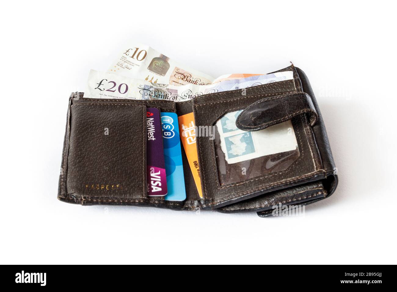Portefeuille repliable en cuir marron ouvert contenant 10 £ et 20 £ de billets et de cartes de crédit britanniques Banque D'Images