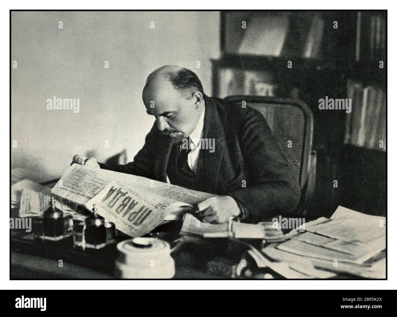 LÉNINE Archive c1918 Vladimir Lénine lisant une copie du journal PRAVDA dans son bureau Moscou URSS (1870-1924) Banque D'Images
