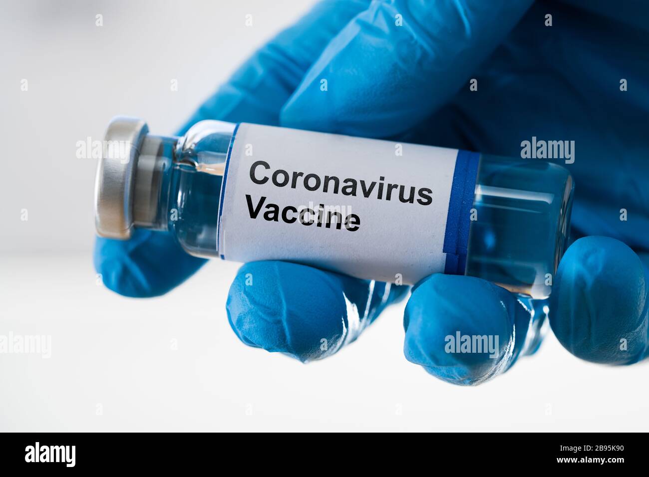 Main de médecin dans les gants pour le vaccin contre le coronavirus Banque D'Images