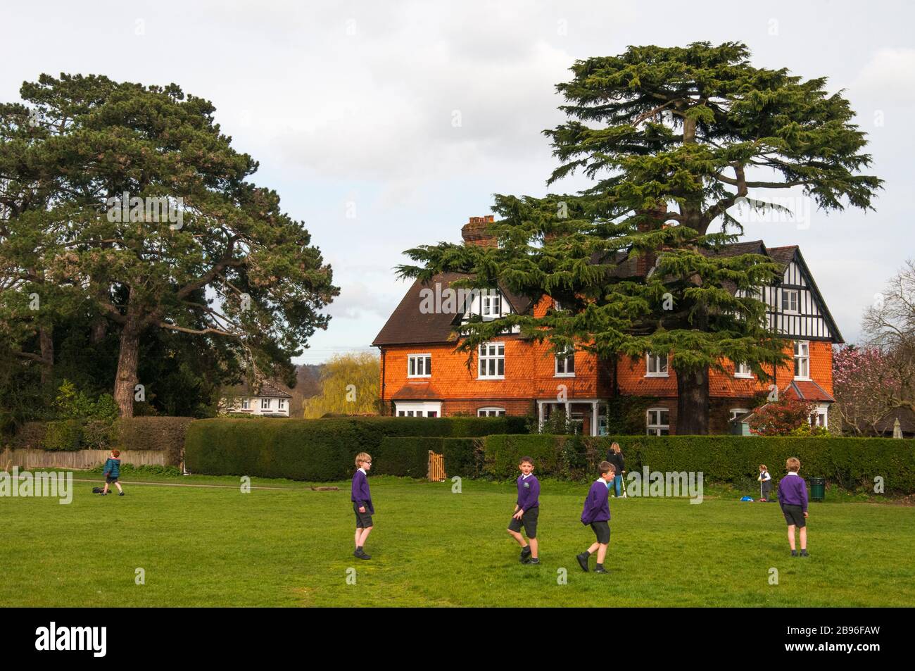 Enfants jouant sur le vert du village à Brockham, Surrey, Angleterre Banque D'Images