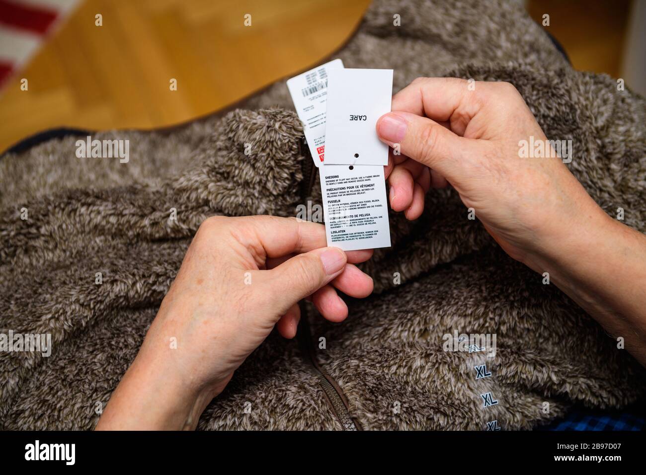 Paris, France - 19 févr. 2020: POV of senior Hands tenant des vêtements  étiquette d'un manteau chaud Uniqlo et des informations importantes sur le  raclage Photo Stock - Alamy
