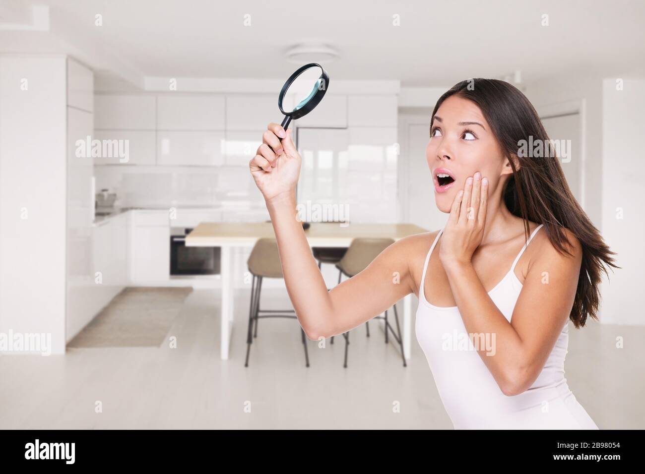 Accueil COVID-19 nettoyage inspection choqué femme asiatique surpris de découvrir des germes partout dans la cuisine sur le comptoir, les surfaces sales qui ont besoin d'être Banque D'Images