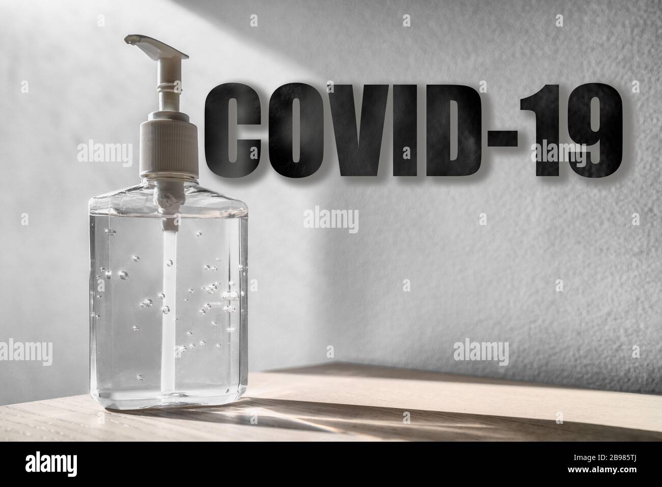 Coronaviru COVID-19 titre de texte sur fond de bouteille de désinfectant pour la main avec texture Banque D'Images