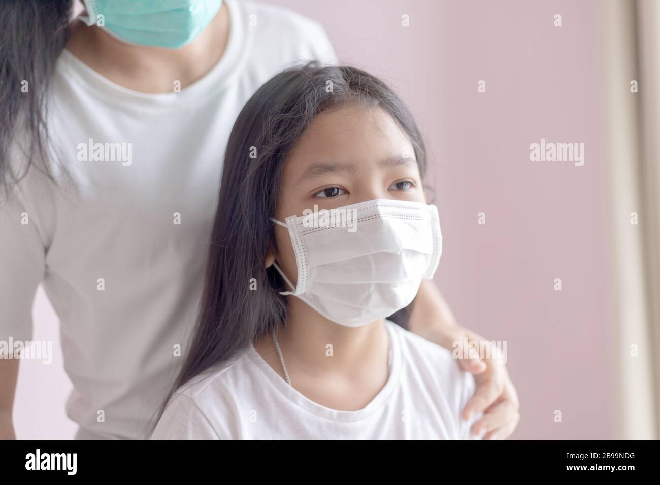 La femme et la fillette portent un masque médical de protection. La protection contre l'épidémie de grippe, de coronavirus ou de COVID-19 et la maladie avec le smog Banque D'Images