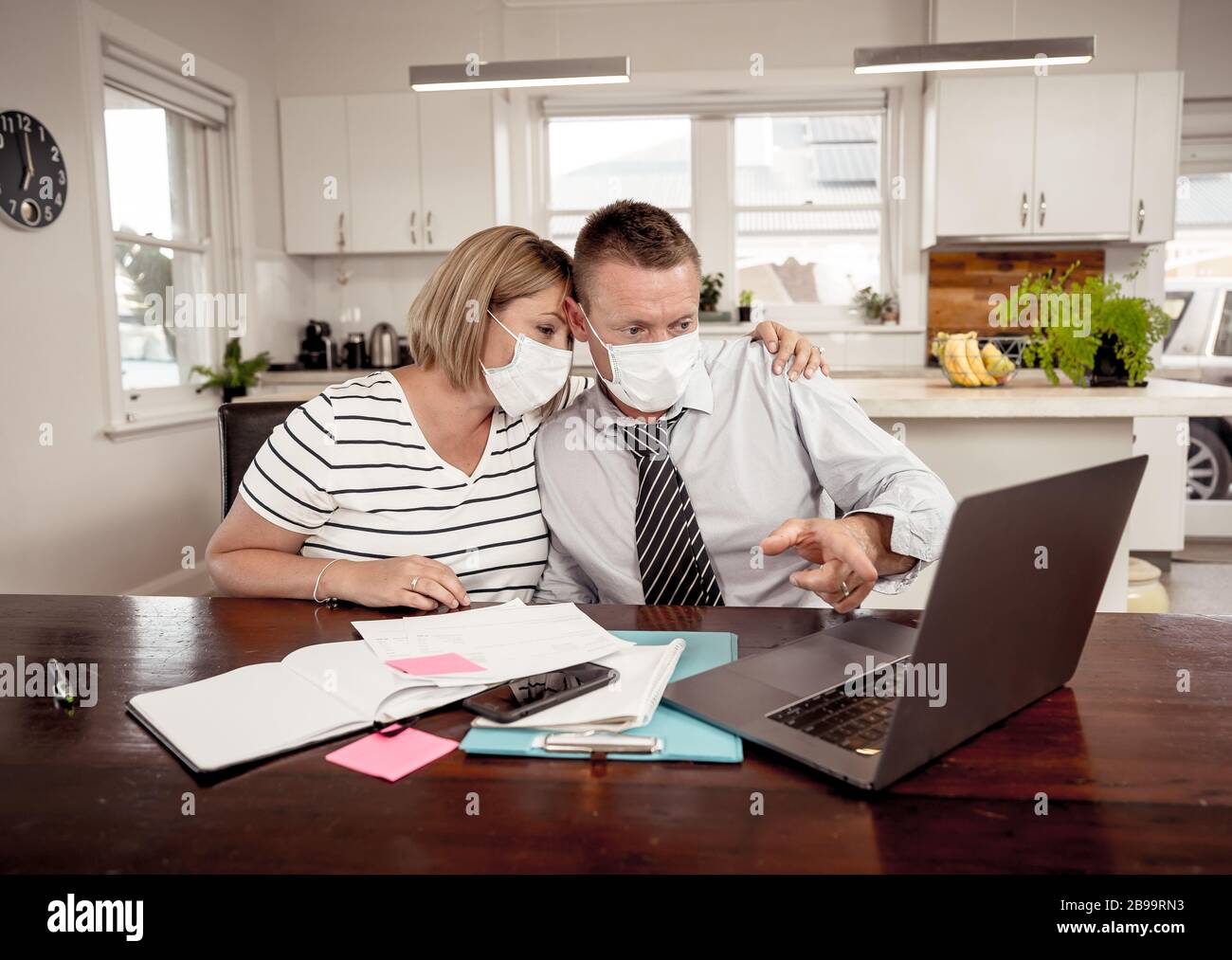 Récession économique du coronavirus. J'ai souligné le couple avec des masques dans l'auto-isolation sur les finances de la maison et les dettes des petites entreprises pendant l'arrêt de quarantaine Banque D'Images