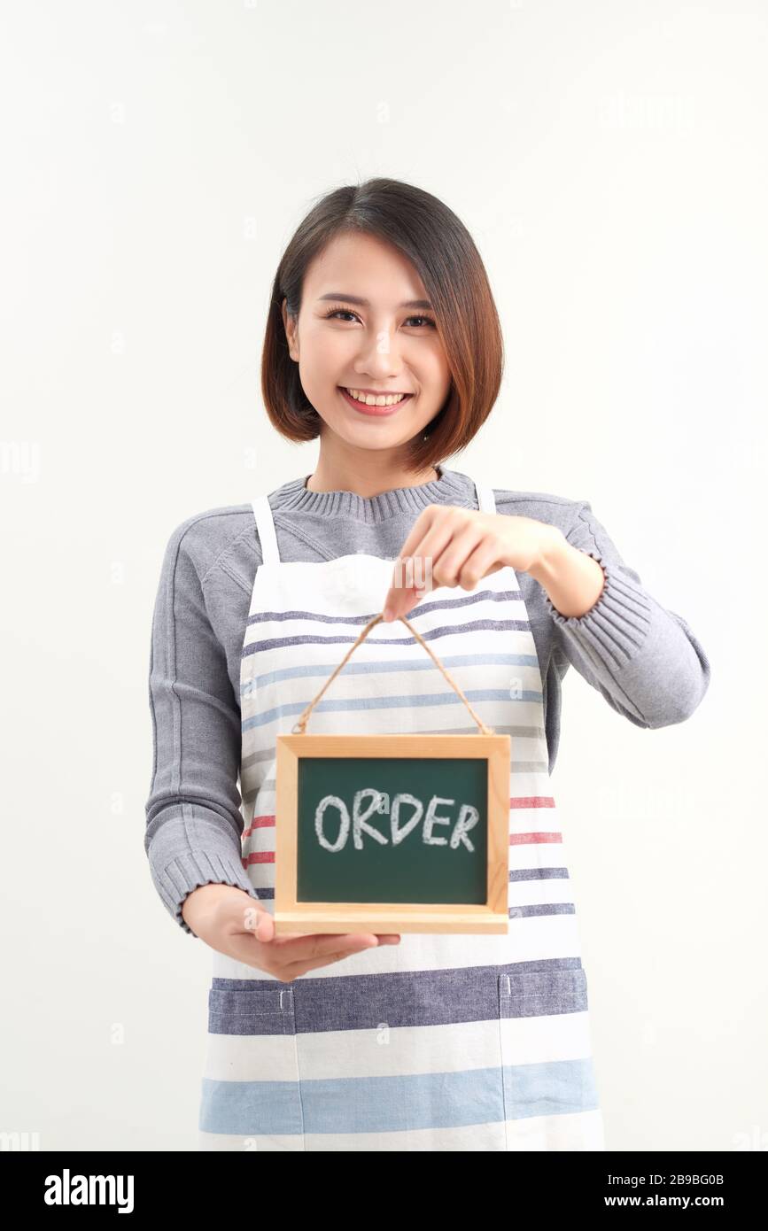 Jeune barista asiatique tenant un menu de tableau de surveillance en blanc Banque D'Images