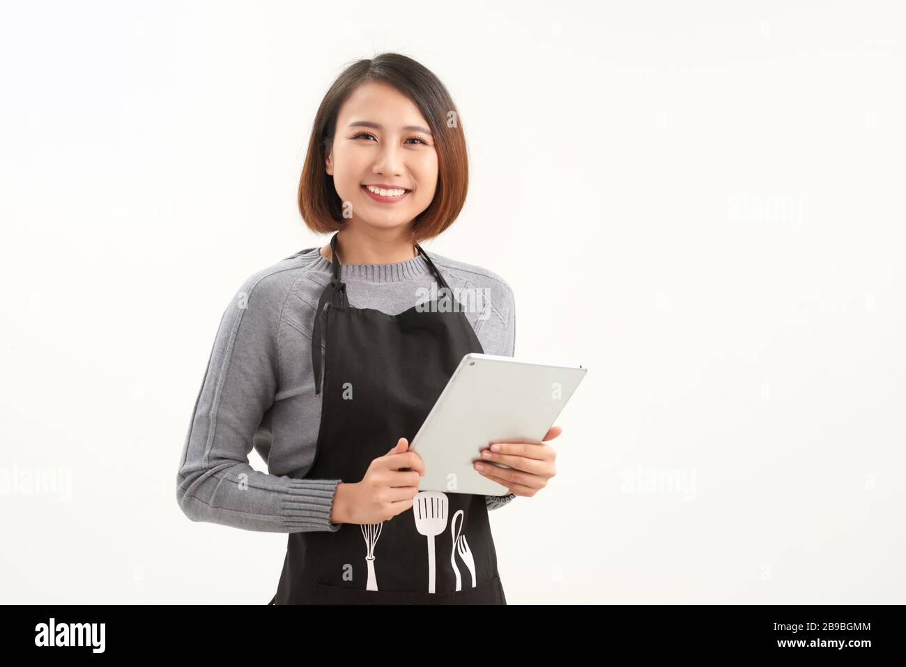 Belle femme propriétaire utilisant une tablette numérique sur blanc Banque D'Images