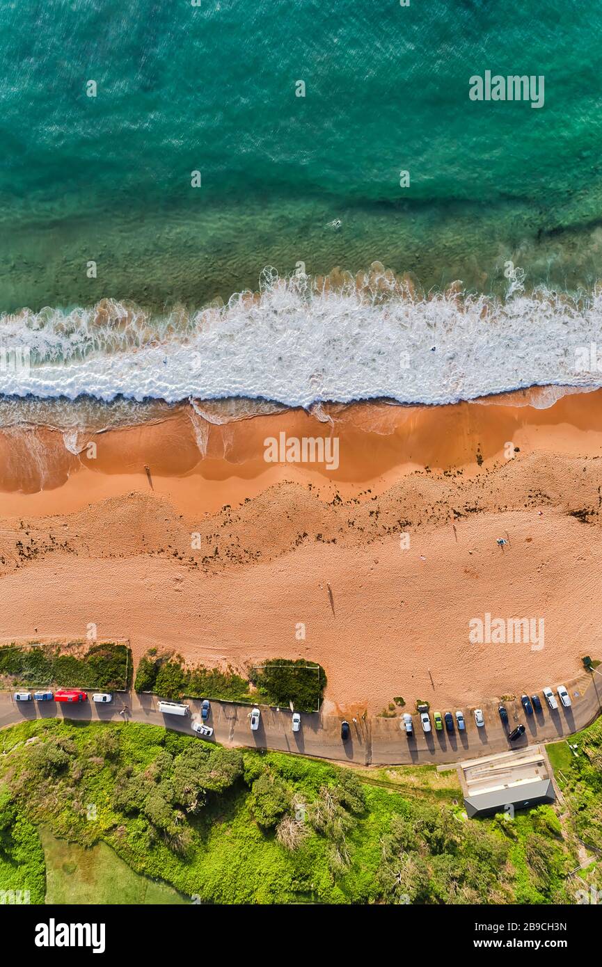 Les surfeurs et les nageurs sur la plage de Warriewood, sur les plages du nord de Sydney, une journée ensoleillée. Banque D'Images