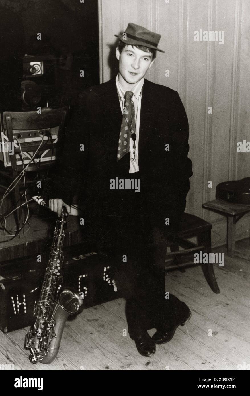 Un jeune homme en costume, cravate et chapeau se tient sur une scène avec  un saxophone. [traduction automatique] Photo Stock - Alamy