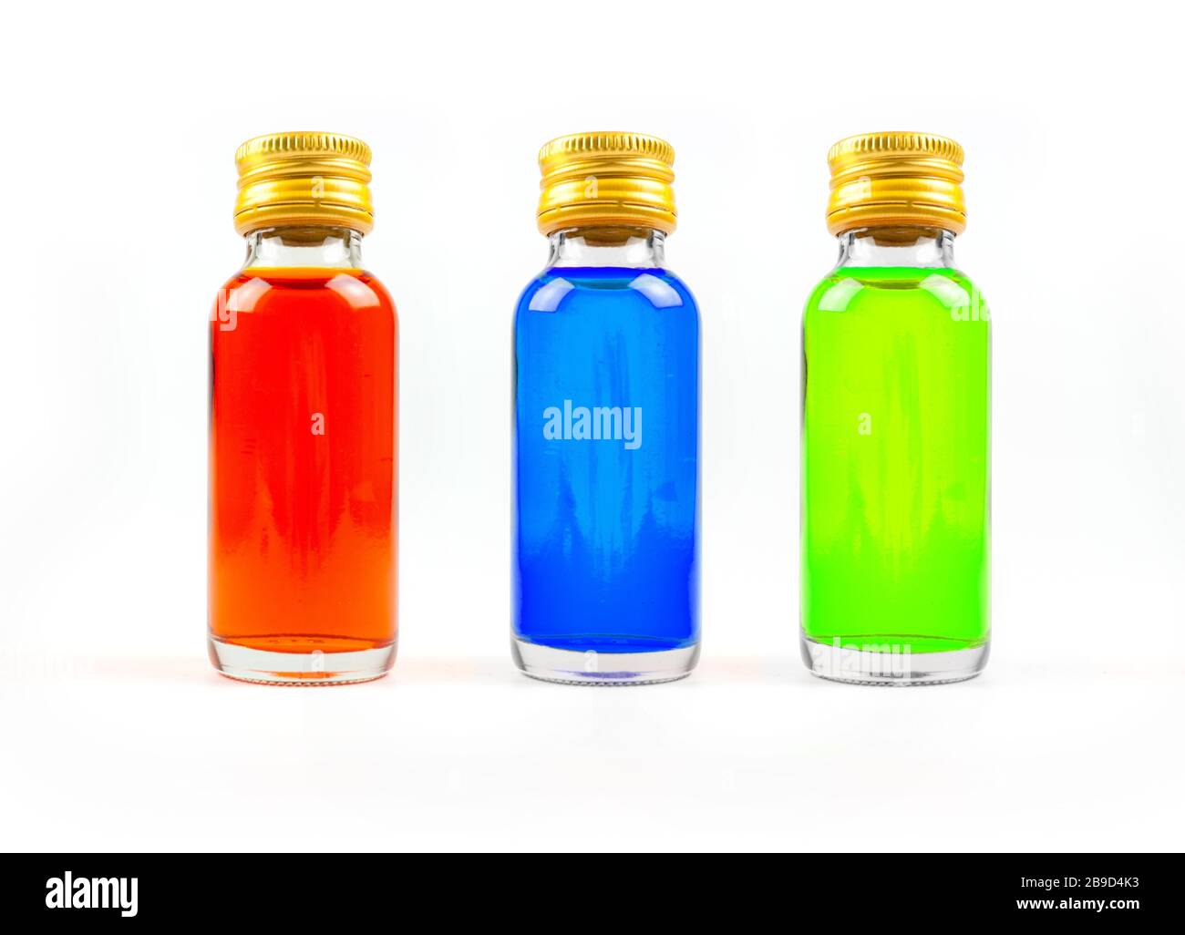 Coloration alimentaire dans les bouteilles de verre sur fond blanc isoler, jaune, bleu, vert, trois bouteilles de coloration alimentaire Banque D'Images