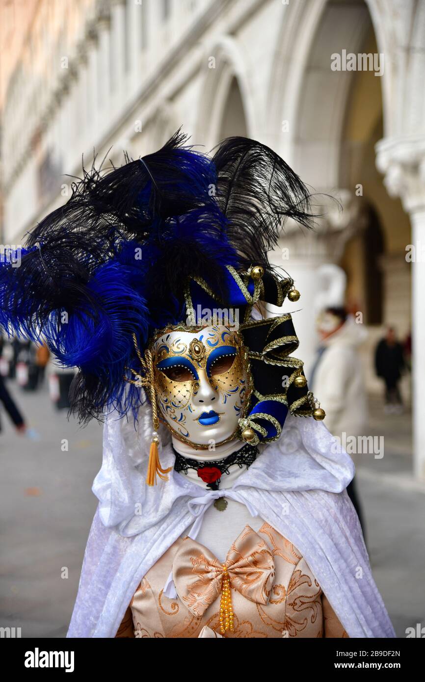Gros plan sur les femmes masquées dans une robe colorée sur fond de palais pendant le carnaval vénitien Banque D'Images