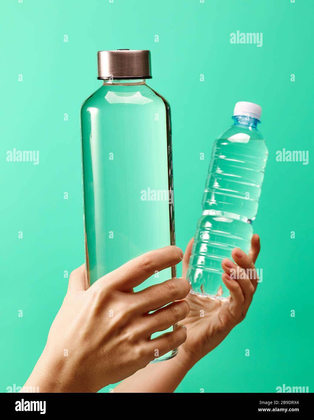 Concept zéro déchet - bouteille d'eau en verre réutilisable vs bouteille en  plastique à usage unique sur fond vert menthe Photo Stock - Alamy