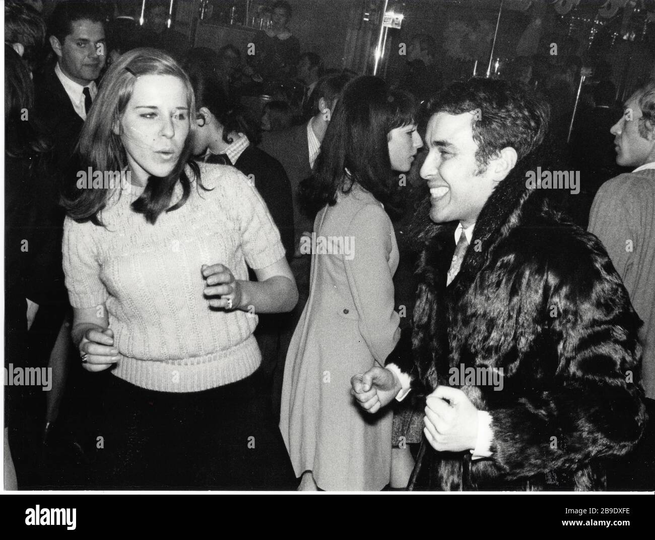 Un couple dansait dans une discothèque de Munich. La femme porte un pull à  manches courtes, l'homme porte un manteau de fourrure. [traduction  automatique] Photo Stock - Alamy