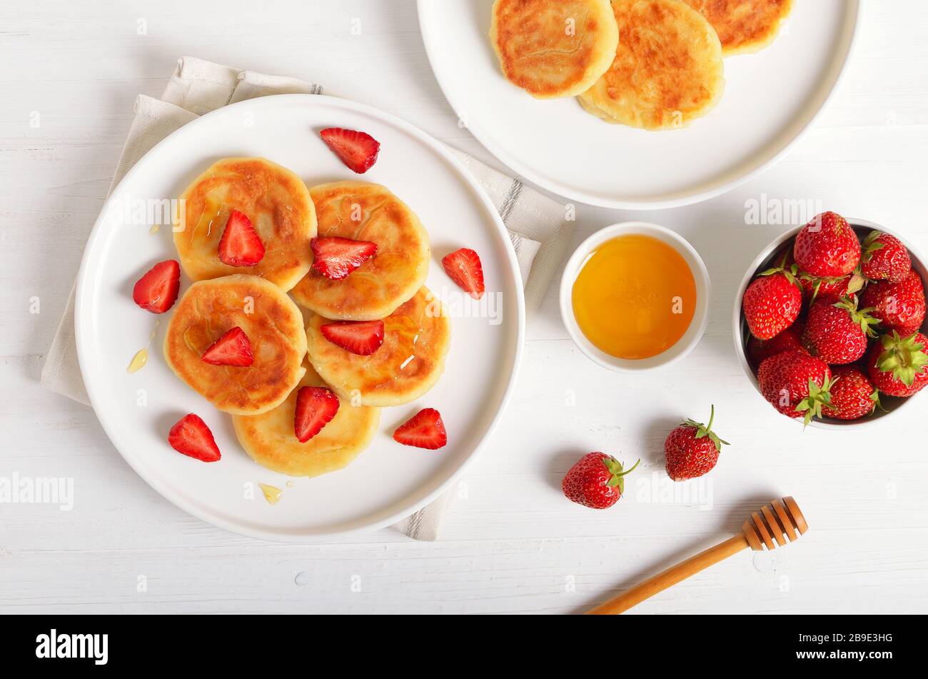 Crêpes de fromage cottage avec tranches de fraise et de miel. Petit déjeuner sain. Haut de la vue, télévision lay Banque D'Images