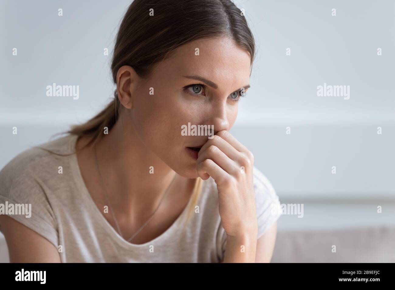 La tête a bouleversé la jeune femme réfléchie regardant à distance Banque D'Images