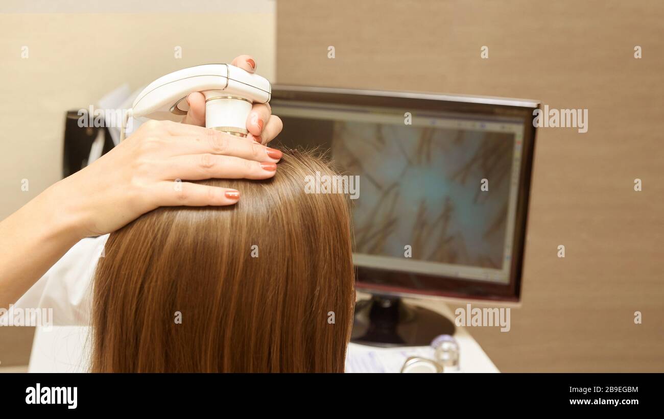 Femme vérifier les cheveux de tête en clinique. Banque D'Images