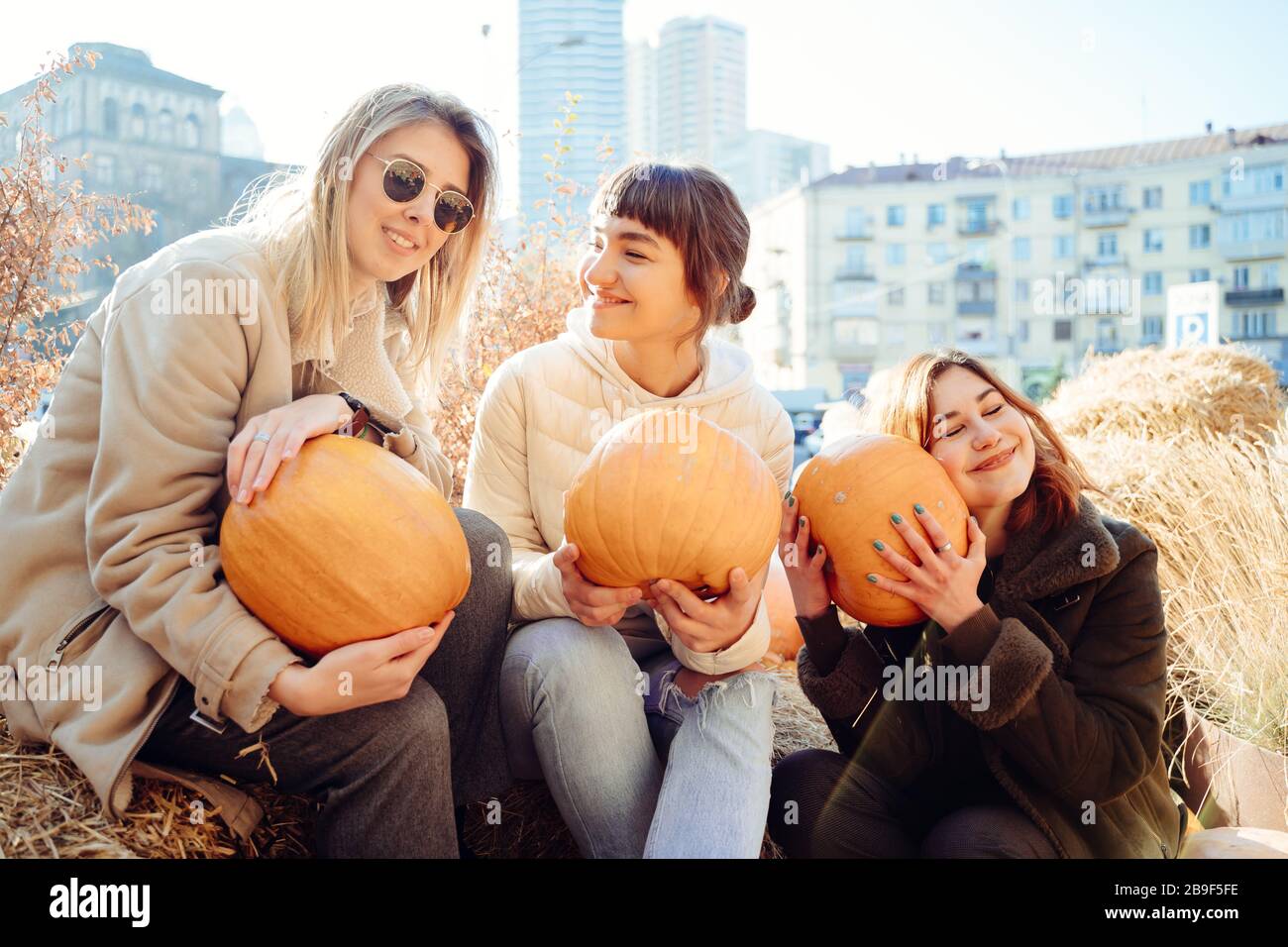 Les filles tient les citrouilles dans les mains sur le fond de la rue. Banque D'Images