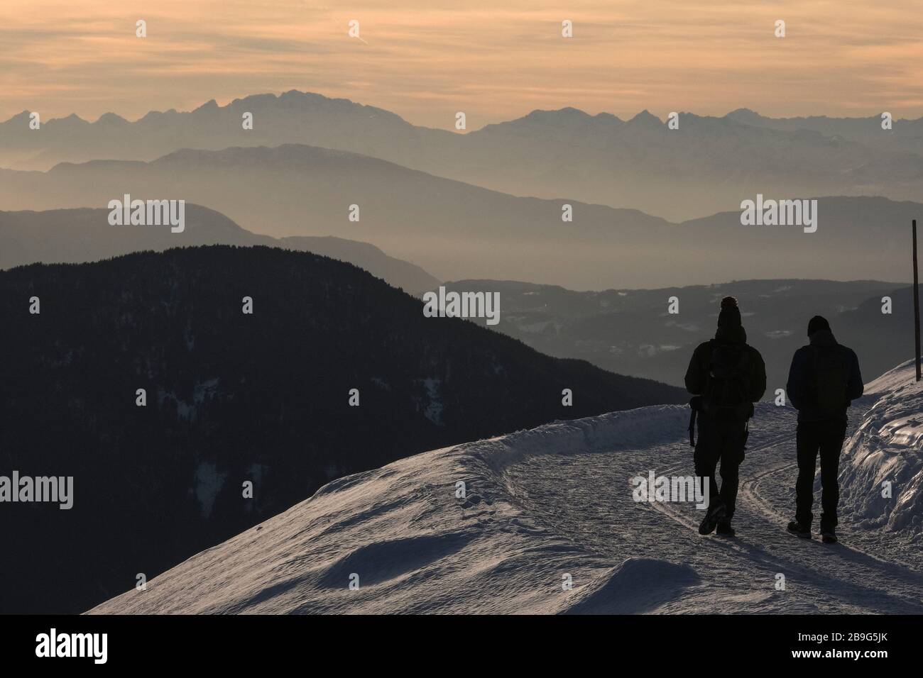 Des gens silhouettés qui font de la randonnée sur la montagne enneigée, Brixen, Tyrol du Sud, Italie Banque D'Images