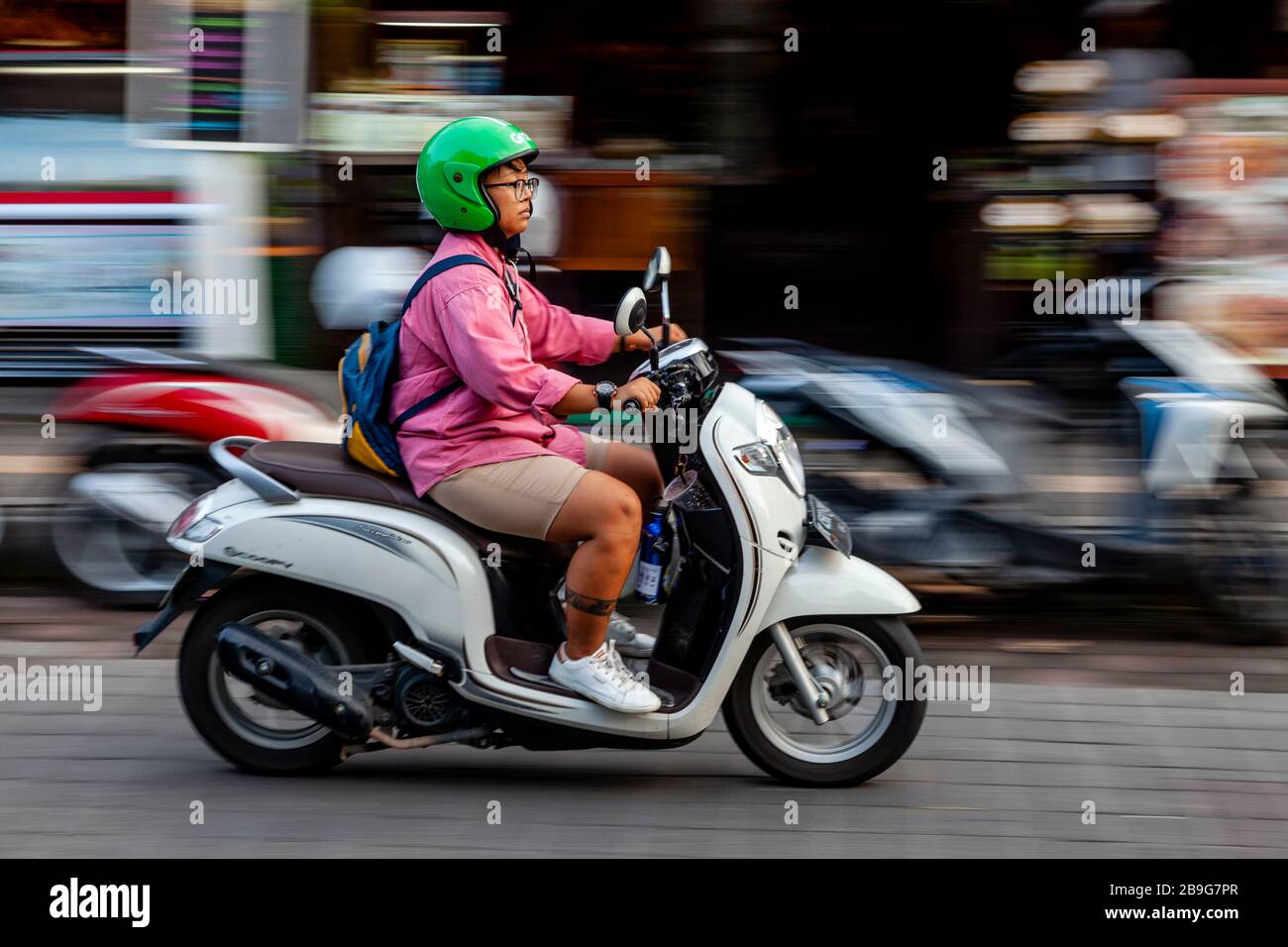 Une femme locale voyageant en moto, Ubud, Bali, Indonésie. Banque D'Images