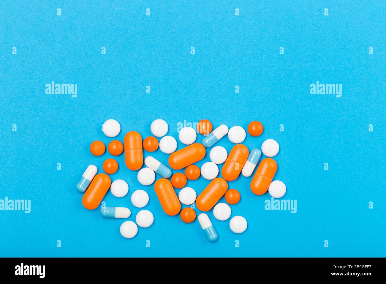 Assortiment de pilules, comprimés et capsules de médecine pharmaceutique sur fond bleu. Espace libre. Concept de santé. Banque D'Images