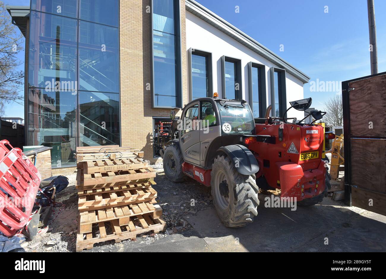 Un travailleur de la construction conduit des machines sur un site de construction géré par le conseil à Billericay Essex, le lendemain que le Premier ministre Boris Johnson a mis le Royaume-Uni en position de verrouillage pour aider à freiner la propagation du coronavirus. Banque D'Images