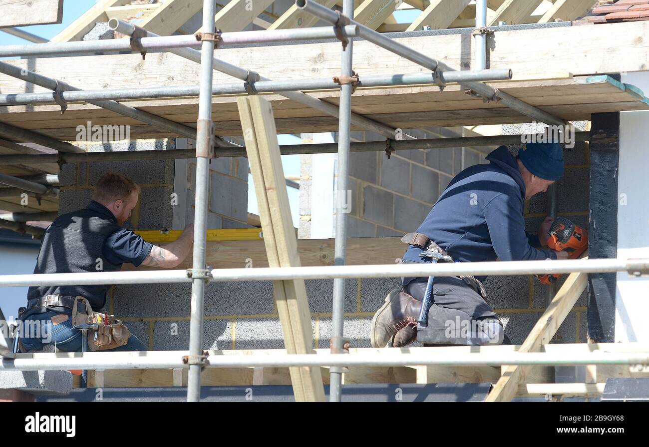 Les constructeurs indépendants travaillent sur une propriété à Billericay, dans l'Essex, le lendemain que le Premier ministre Boris Johnson a mis le Royaume-Uni en place pour aider à freiner la propagation du coronavirus. Banque D'Images