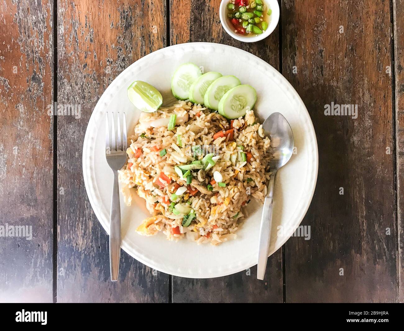 Riz frit avec calmar de crevettes aux fruits de mer et œufs sur table en bois Banque D'Images