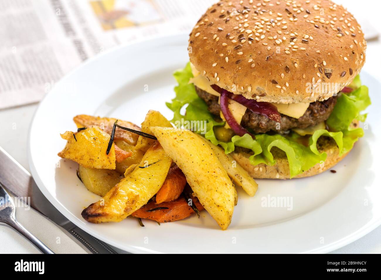 Délicieux hamburger de bœuf grillé avec des pommes de terre servies sur une plaque avec espace de copie Banque D'Images