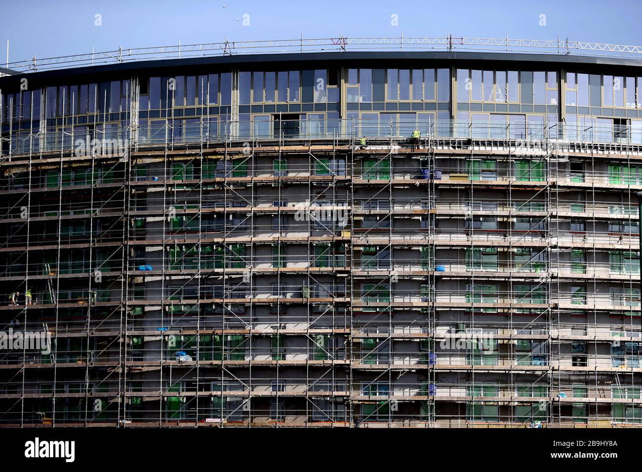 Les travailleurs de la construction sur place dans un bloc d'appartements à Nottingham la journée après que le Premier ministre Boris Johnson a mis le Royaume-Uni en place pour aider à freiner la propagation du coronavirus. Banque D'Images