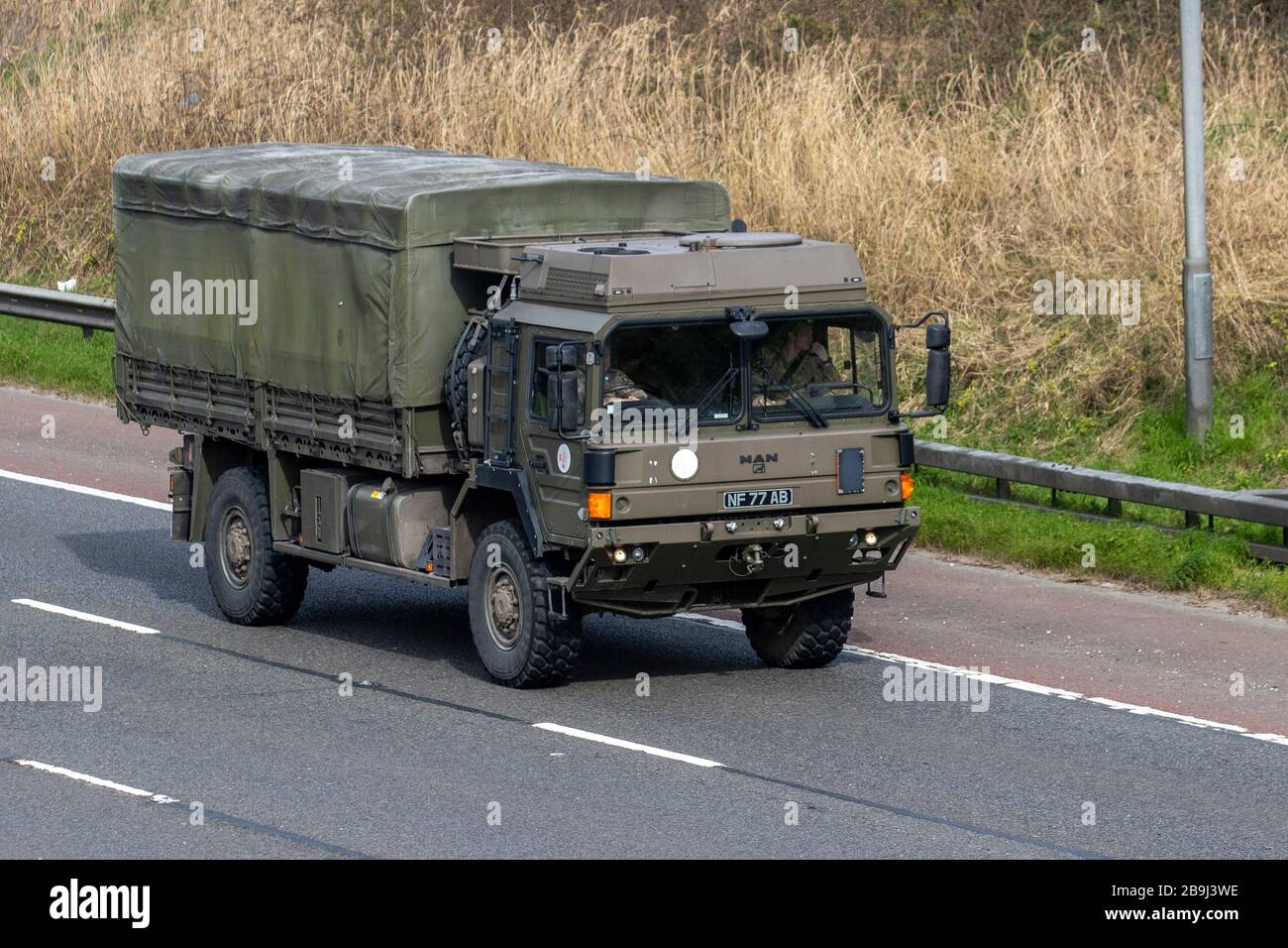 Camion de service général vert de l'armée britannique, homme recouvert de toile HX60 18,330 4x4 véhicule militaire tractant une remorque ; voyageant sur l'autoroute M6 Royaume-Uni Banque D'Images