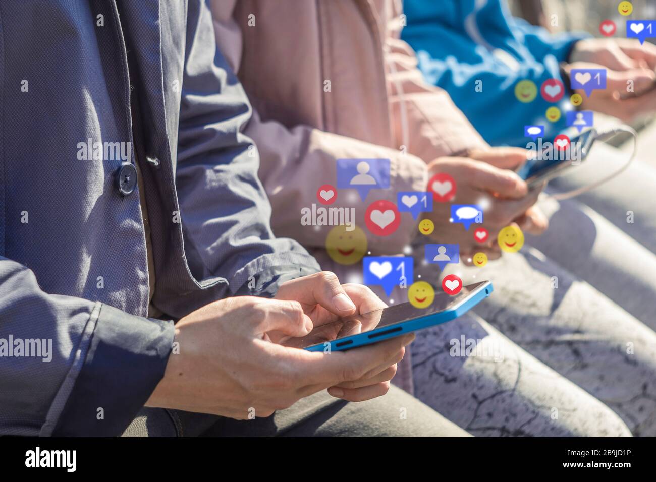 Les utilisateurs utilisent un réseau social avec des icônes de notification sur les smartphones. Les adolescents regardaient des vidéos en direct sur leur téléphone mobile. Banque D'Images