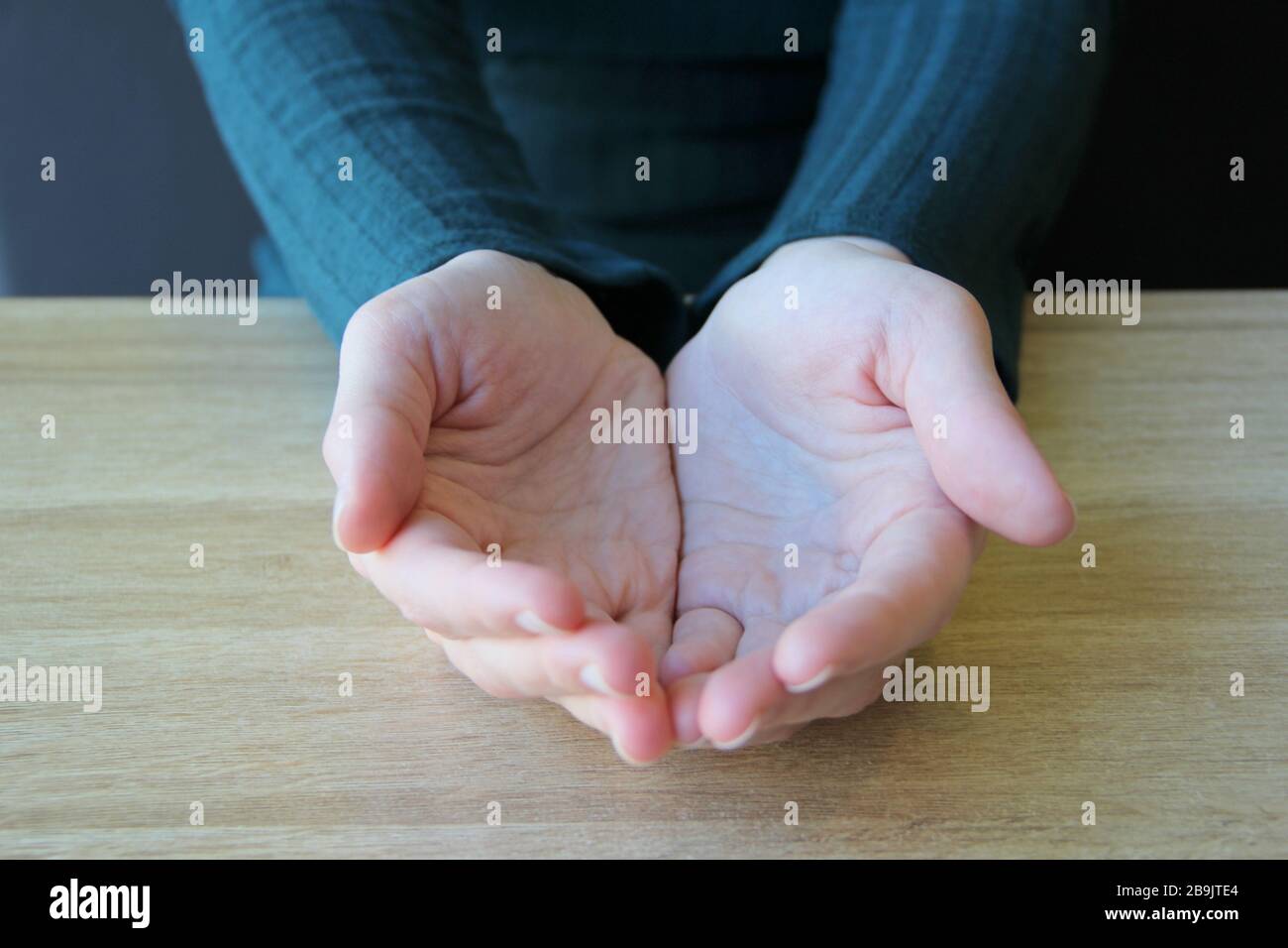 Mains vides repliées avec les paumes sur fond clair. Stocker la photo pour le Web et l'imprimer avec un espace vide pour le texte et la conception Banque D'Images