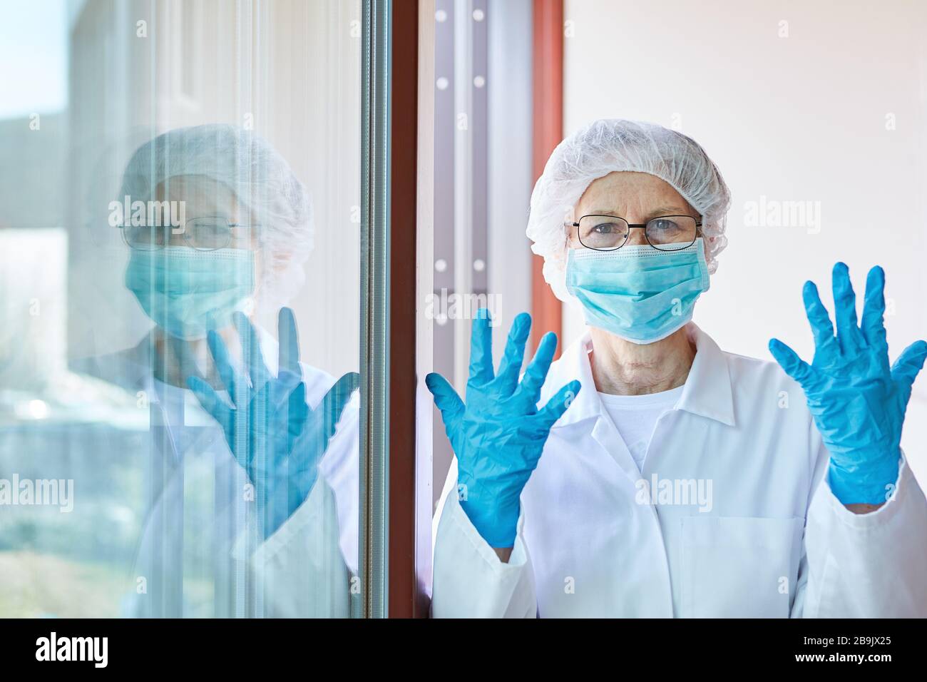 Soignant en clinique avec des vêtements de protection et des gants jetables pendant l'épidémie de coronavirus Banque D'Images