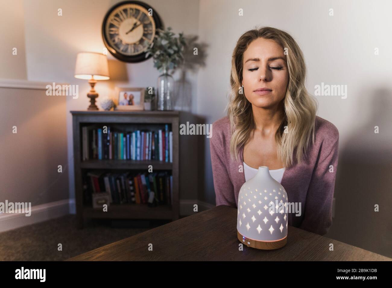 Jeune femme qui a frappé son diffuseur d'huile essentiel Banque D'Images
