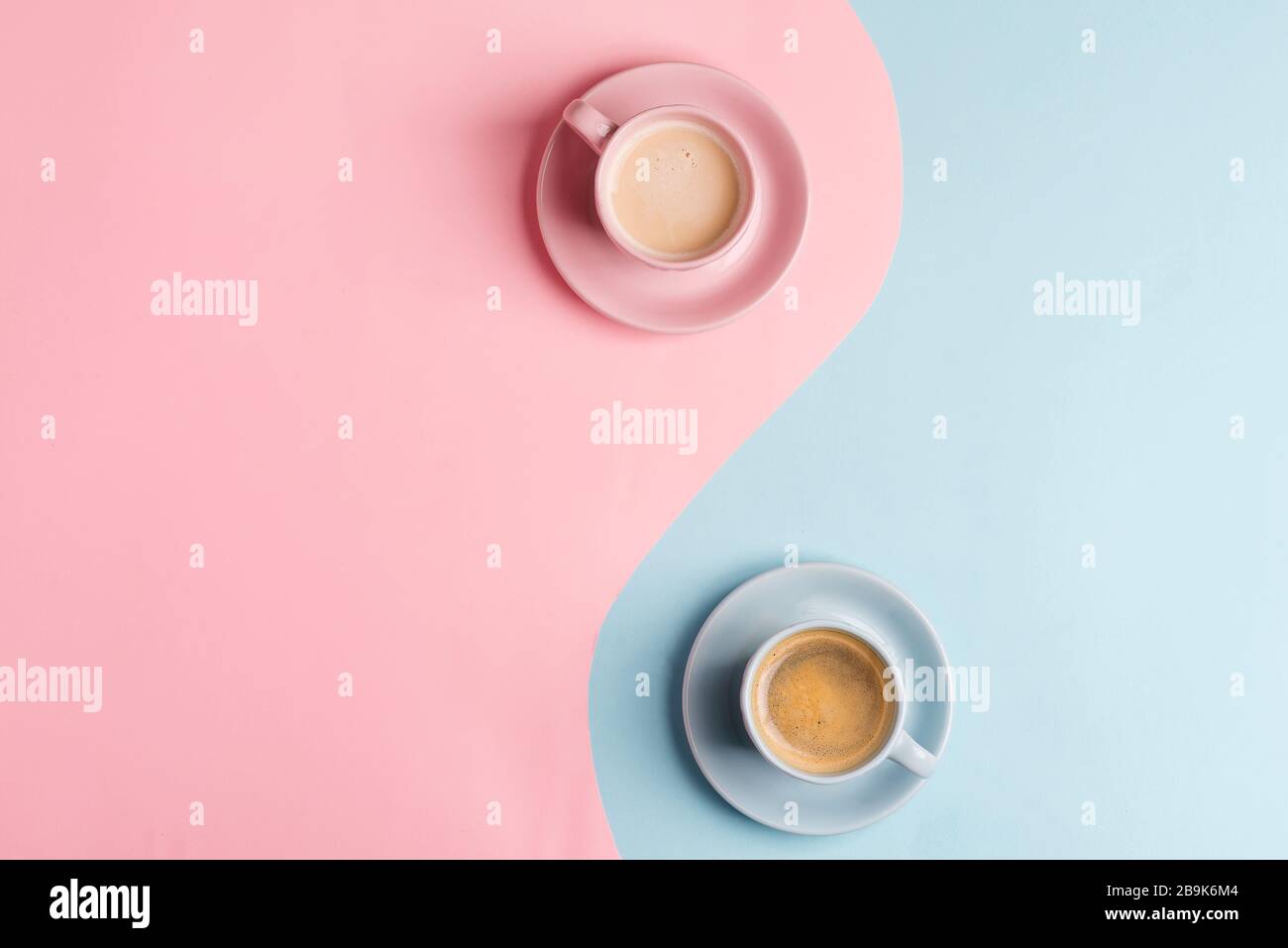 Composition décorative de deux tasses en céramique de café aromatique fraîchement préparé sur un fond rose pastel bleu comme symbole de yin et de yang. Fla Banque D'Images