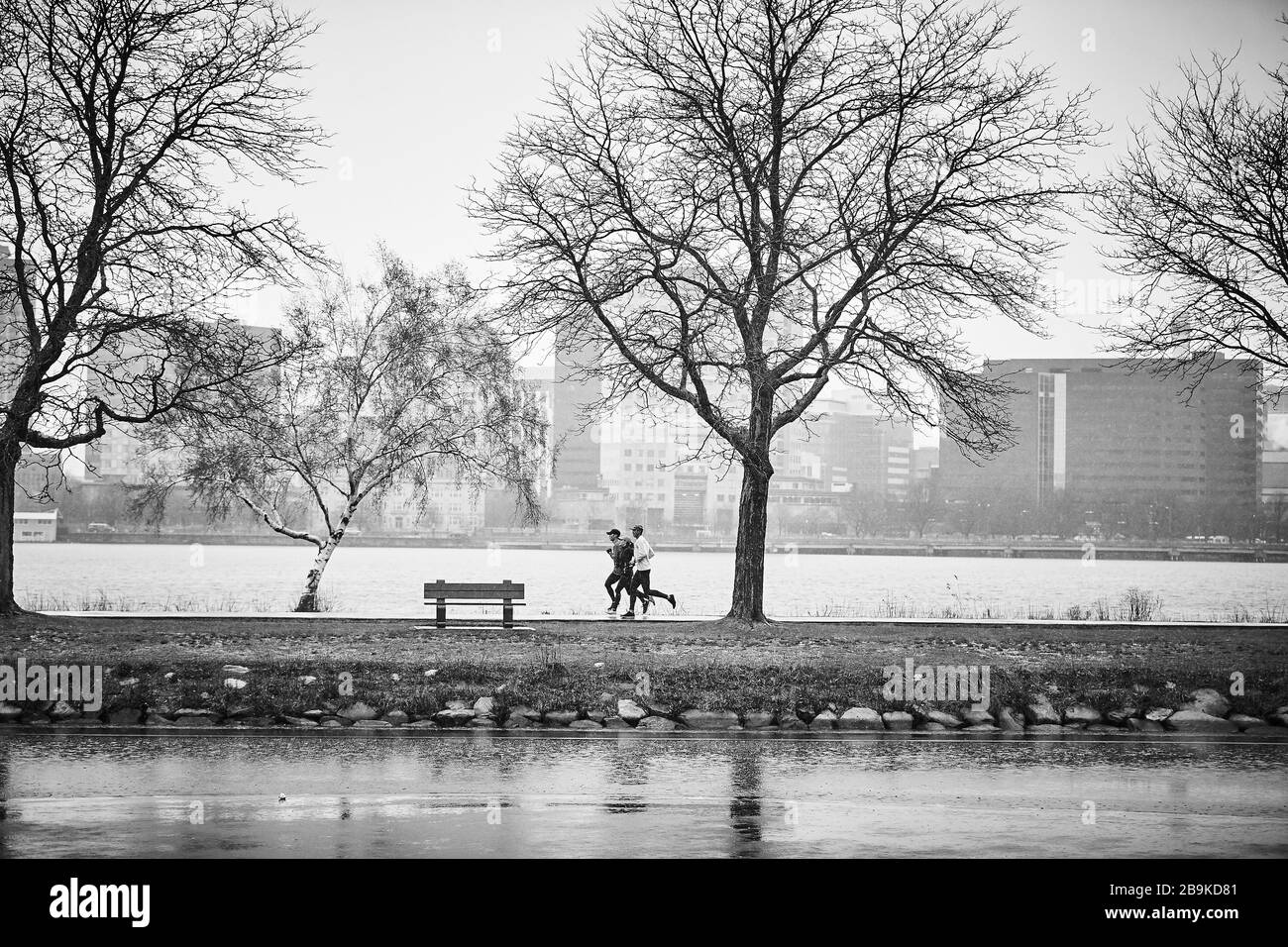 Un groupe court dans la pluie froide le long de la rivière Charles à Boston. Banque D'Images