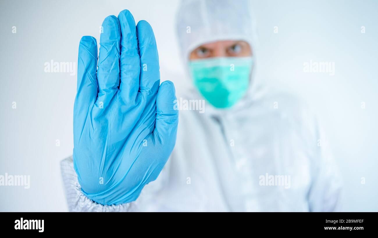 Un homme caucasien dans un costume et un masque de protection montre le signe stop du virus corona. Risque biologique. Épidémie du coronavirus chinois. COVID pandémique Banque D'Images