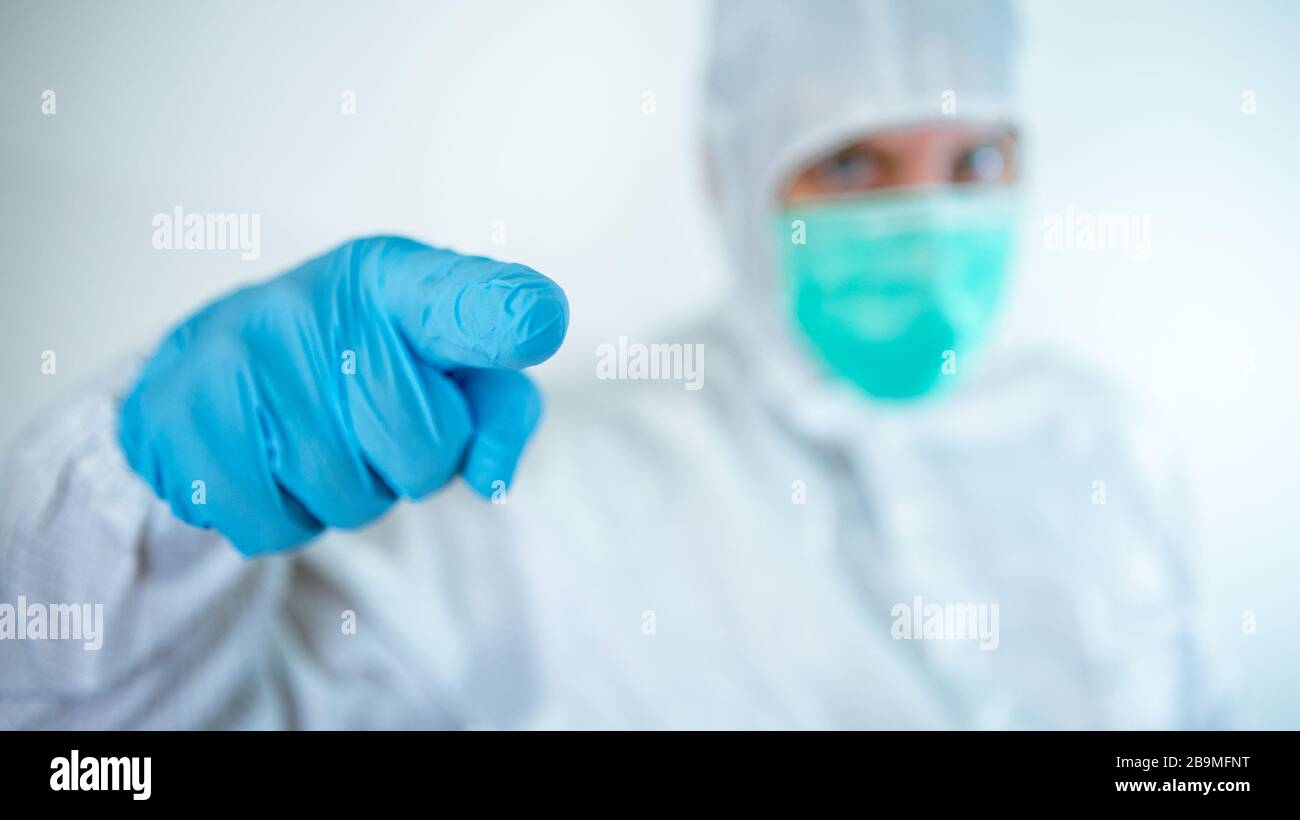 Homme de pointage de la main du médecin. Un homme caucasien dans un costume de protection et un masque montre la signalisation ok. Concept médical et de soins de santé, isolé sur un ba blanc Banque D'Images