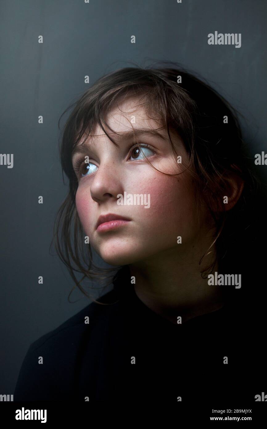 Garçon de 11 ans regardant hors d'une fenêtre pendant la pandémie de coronavirus, Barcelone, Espagne. Banque D'Images