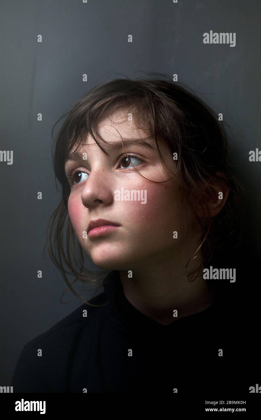 Garçon de 11 ans regardant hors d'une fenêtre pendant la pandémie de coronavirus, Barcelone, Espagne. Banque D'Images