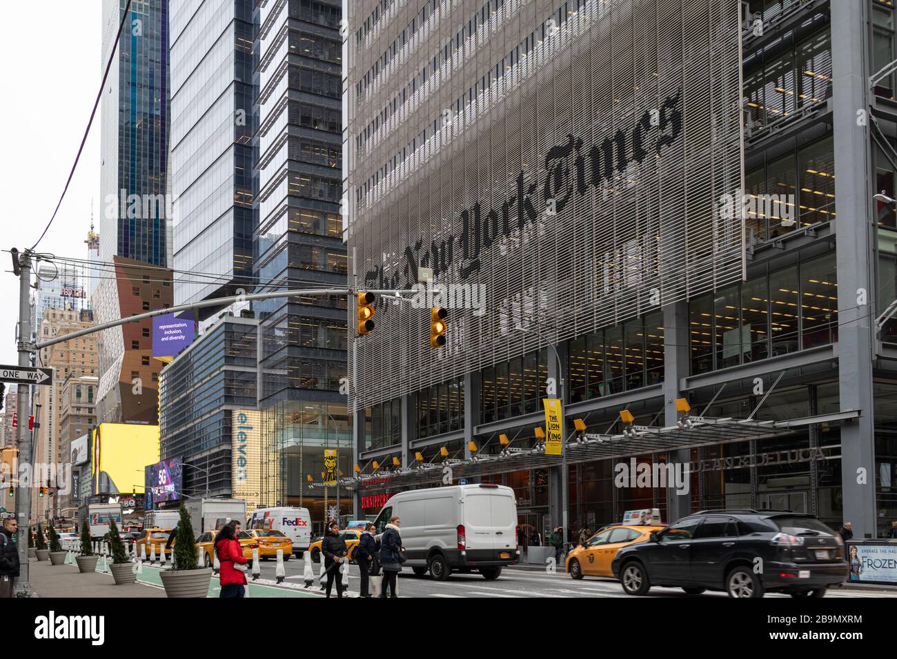 Le bâtiment du quartier général du New York Times, situé dans la huitième Avenue, offre une vue extérieure sur la lumière du jour de la 40ème et de la 41ème rue avec des personnes et des voitures dans la rue Banque D'Images
