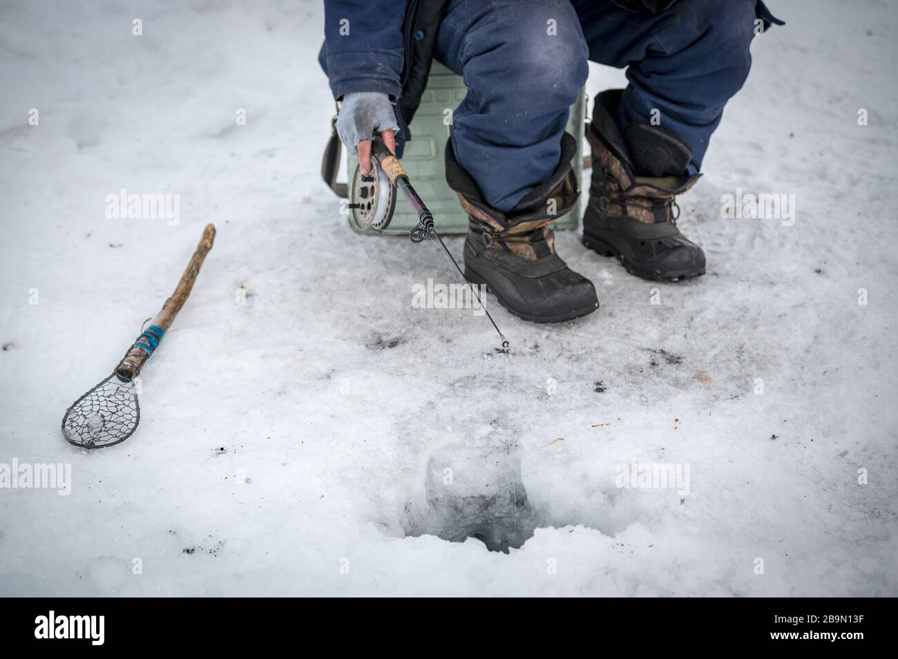 Lac Baikal, Sibérie, Russie - 05 mars 2020 : pêche sur glace d'hiver. Un pêcheur pêche sur des flèches près de tentes et de voitures sur le lac Baikal en mars d Banque D'Images Lac Baikal, Sibérie, Russie - 05 mars 2020 : pêche sur glace d'hiver. Un pêcheur pêche sur des flèches près de tentes et de voitures sur le lac Baikal en mars d Banque D'Images