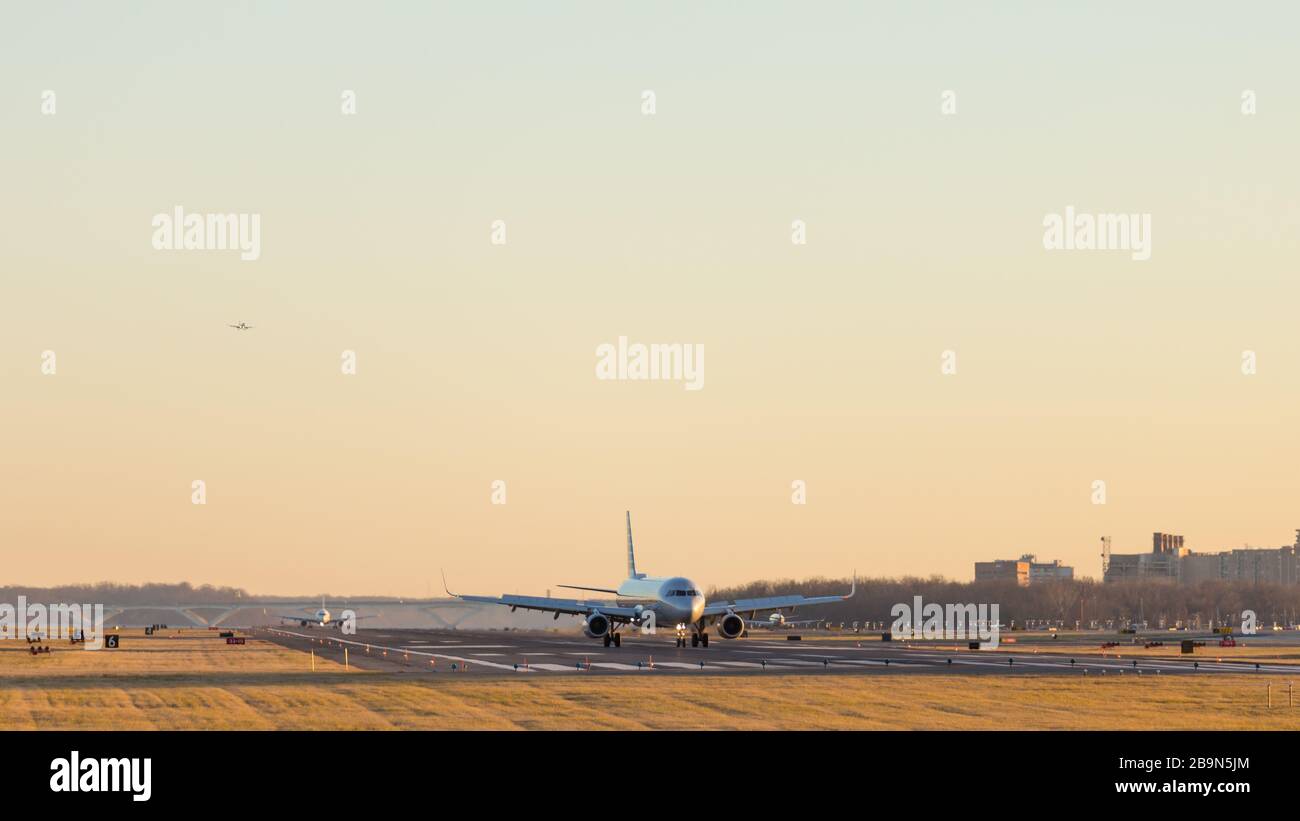 Sur la piste 01 de l'aéroport national Reagan, un aéronef se prépare à quitter la piste après l'atterrissage, à prendre un autre train pour le décollage et un troisième est en shor Banque D'Images