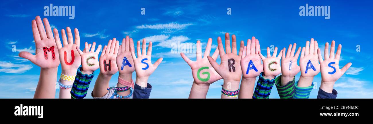 Enfants mains construire Word Muchas Gracias signifie Merci, ciel bleu Banque D'Images