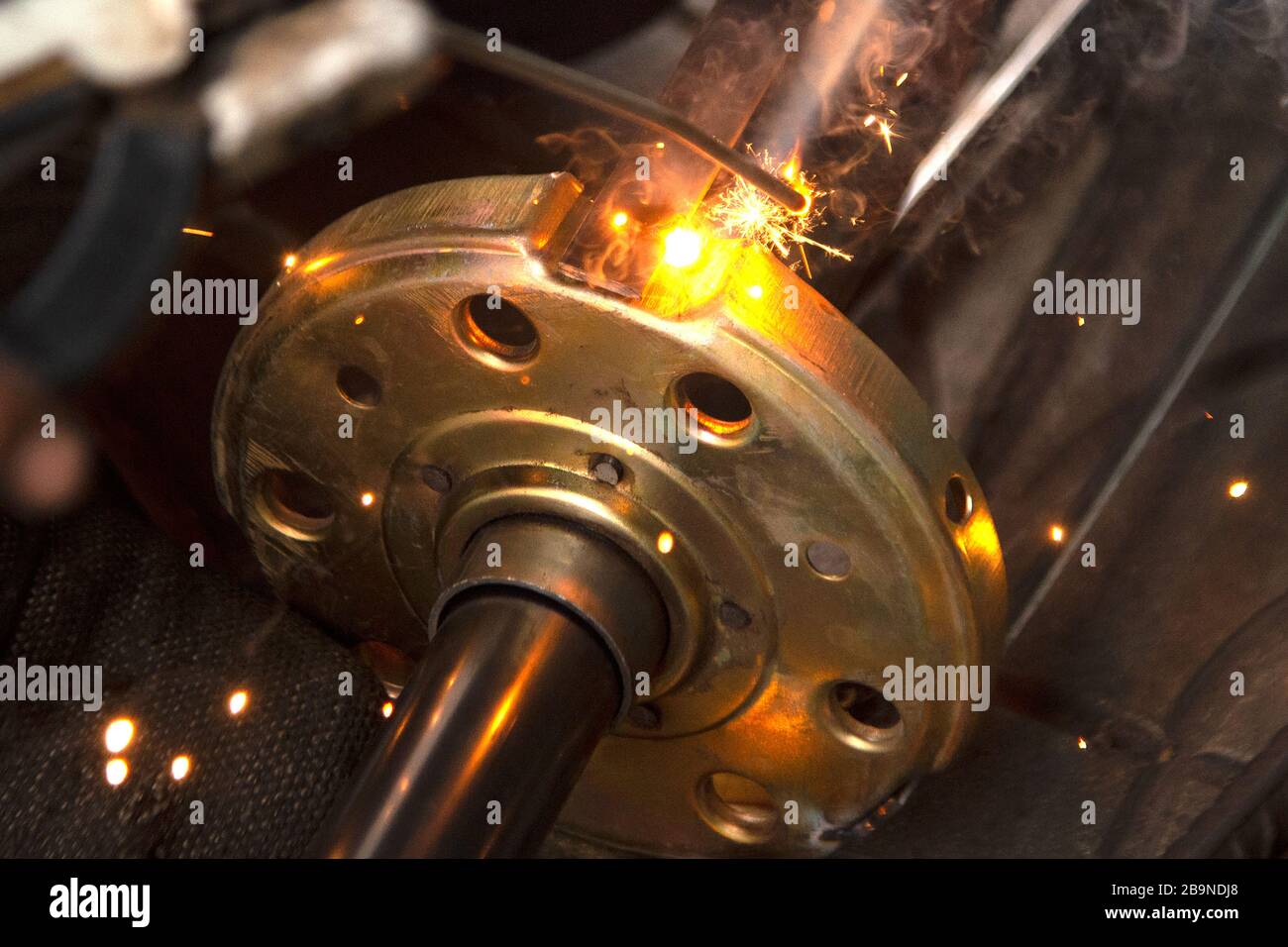 Le travailleur soudure une partie métallique des détails de la trappe de levage de roulement du système. Mise au point sélective. Banque D'Images