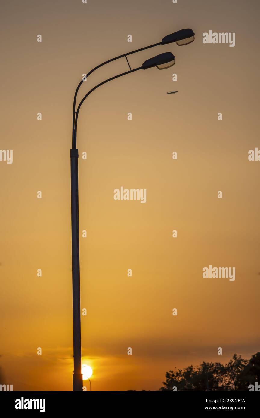 Avions volants et lampadaires au coucher du soleil. Avion passager. Fond dégradé lumineux. Banque D'Images